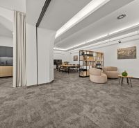 Offices with carpet, comfortable sofas, a wooden kitchenette, and a shelving system.