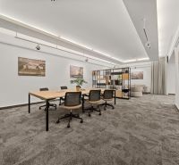 Offices with a conference table, chairs, and a shelf, carpet, simple white walls.