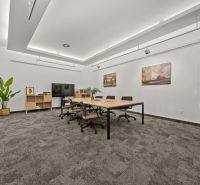 Offices with a conference table, office chairs, and decor in neutral colors.