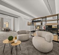 Modern offices with comfortable chairs, tables, and shelving systems, on carpet.