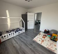 Children's room in a 3-room apartment with a gray-brown floor with a wood decor.