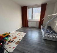 A children's room in a 3-room apartment with a wooden decor floor and a bed.