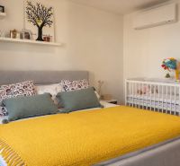 Bedroom in a 3-room apartment with a large bed, a baby crib, and decorations.