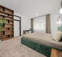 Bedroom in a 2-room apartment with a large bookshelf and a comfortable bed.