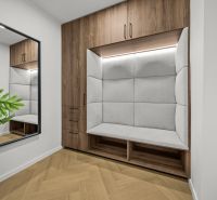 The interior with a wooden decor floor, a mirror, and a built-in bench in a 2-room apartment caught my attention.