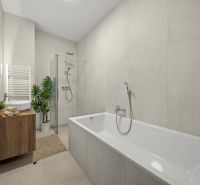 A bathroom with a bathtub and a shower, simple design in a 2-room apartment.
