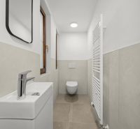 Bathroom in a 2-room apartment with a toilet, sink, and ladder radiator.