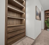 A hallway in a 2-room apartment with shelves and a picture, floor with wood decor.