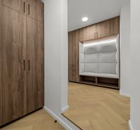 A wardrobe with an armchair and cabinets in a 2-room apartment, floor with a wooden decor.
