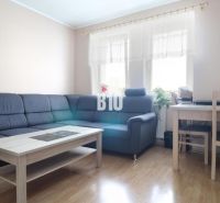 Living room in a 3-room apartment with a corner sofa and wooden floor decor.