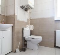 Bathroom with a sink and toilet in a 3-room apartment, light tiles and sanitary fixtures.