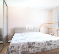 A bright bedroom in a 3-room apartment with a double bed and a wardrobe with a mirror.