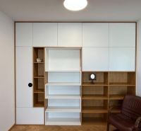 Living wall with shelves and a seat, floor with wood decor, carpet.