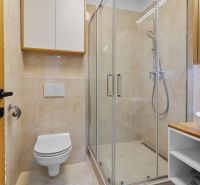 A bathroom with a shower and light tiles in a 3-room apartment.