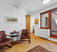Interior of a 3-room apartment with a wooden decor floor and leather armchairs.