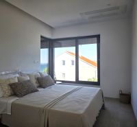 Bedroom with a large bed and a view of the sea, floor with wooden decor.