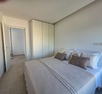 A bedroom with a gray bed, pillows, and a white wardrobe in a 4-room apartment.