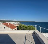 View of the rooftop terrace of an apartment building in Sukošan with the sea and coastal landscape.