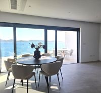 Living room with a table and chairs, large window with a sea view.