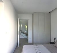 Bedroom in a 4-room apartment with entrance to the bathroom and white staircase.