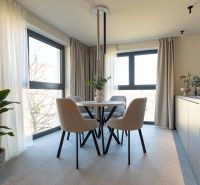 Dining room with a table and four chairs, famous flowers, and curtains in a 4-room apartment.