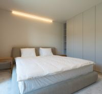 Bedroom in a 4-room apartment with a large bed, wardrobe, and side table.