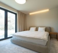 Bedroom with light walls, a bed, and a wardrobe in a 4-room apartment.