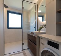 The bathroom in the 4-room apartment contains a shower, a sink, and a washing machine.
