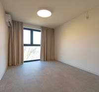 A room in a 4-room apartment with white walls, a large window, and air conditioning.