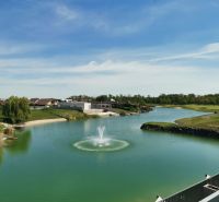 A view of the lake with a fountain and surrounding greenery on Golfová Street in Hrubá Borša.