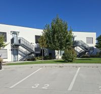 Parking lot and a modern building with an outdoor staircase on Golfová Street in Hrubá Borša.