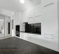 A kitchen in a 2-room apartment with a white kitchen unit and a mirrored wardrobe.