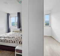 Bedroom and a bright room in a 2-room apartment with a wooden decor floor.