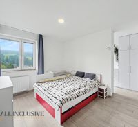 A bright bedroom with a bed, a wardrobe, and a wooden decor floor in a 2-room apartment.