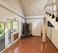 Interior with a tiled stove, staircase, and floor with a design in a residential plot.