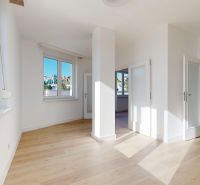 A bright room with large windows, a floor with a wooden decor, a 3-room apartment.