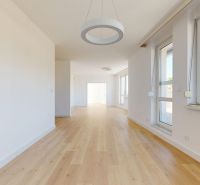 A bright room with large windows and a floor with a wooden decor in a 3-room apartment.