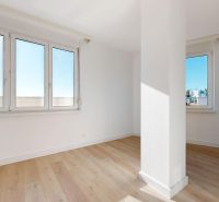 A bright room with white walls and a floor with a wooden decor in a 3-room apartment.