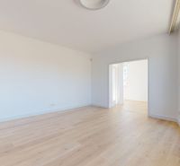 A bright interior of a 3-room apartment with wood-patterned flooring and large windows.
