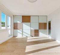 A room with large windows and a built-in wardrobe, a 3-room apartment, floor with wood decor.