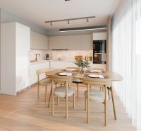 A kitchen in a family house with a dining table and a wooden decor floor.