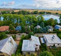 Cottage on Rekreačná Street in Vrbové by the lake, surrounded by greenery and houses.