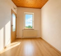 The interior of a cabin with a wooden decor floor and a view from the window.