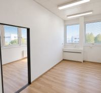 Offices with large windows and wooden decor flooring.