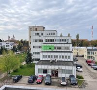 Building on Záhradnícka Street in Komárno, in front of it a parking lot and greenery.
