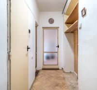 A hallway in a 2-room apartment with shelves and a floor with a wooden decor.