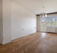 A spacious room with a wood-decor floor in a 2-room apartment.
