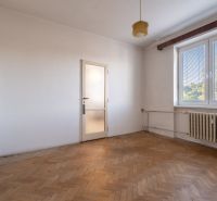 A room in a 2-room apartment with a wooden decor floor and a radiator.
