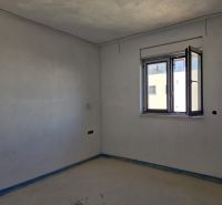 A room in a 3-room apartment with a concrete floor and an open window.