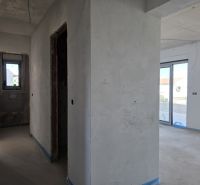 Unfinished 3-room apartment with concrete walls and large windows.